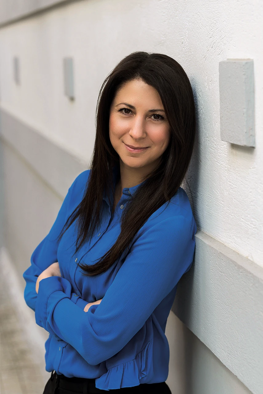 Portrait of Marianna Lourba leaning against a white wall